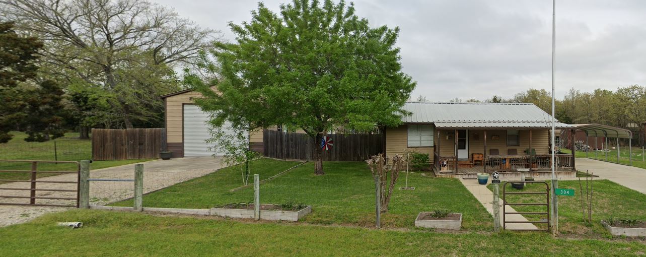 a view of a house with backyard and a tree