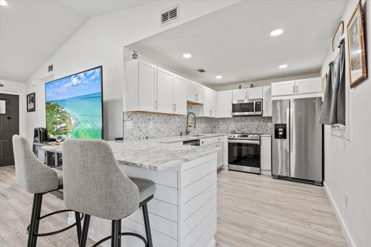 a kitchen with stainless steel appliances granite countertop a stove refrigerator sink and cabinets