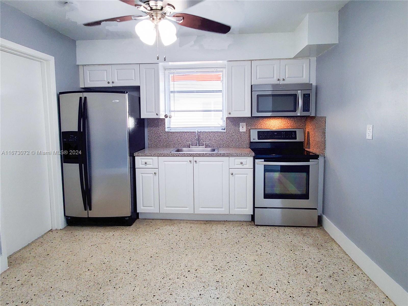 a kitchen with stainless steel appliances a refrigerator stove and microwave