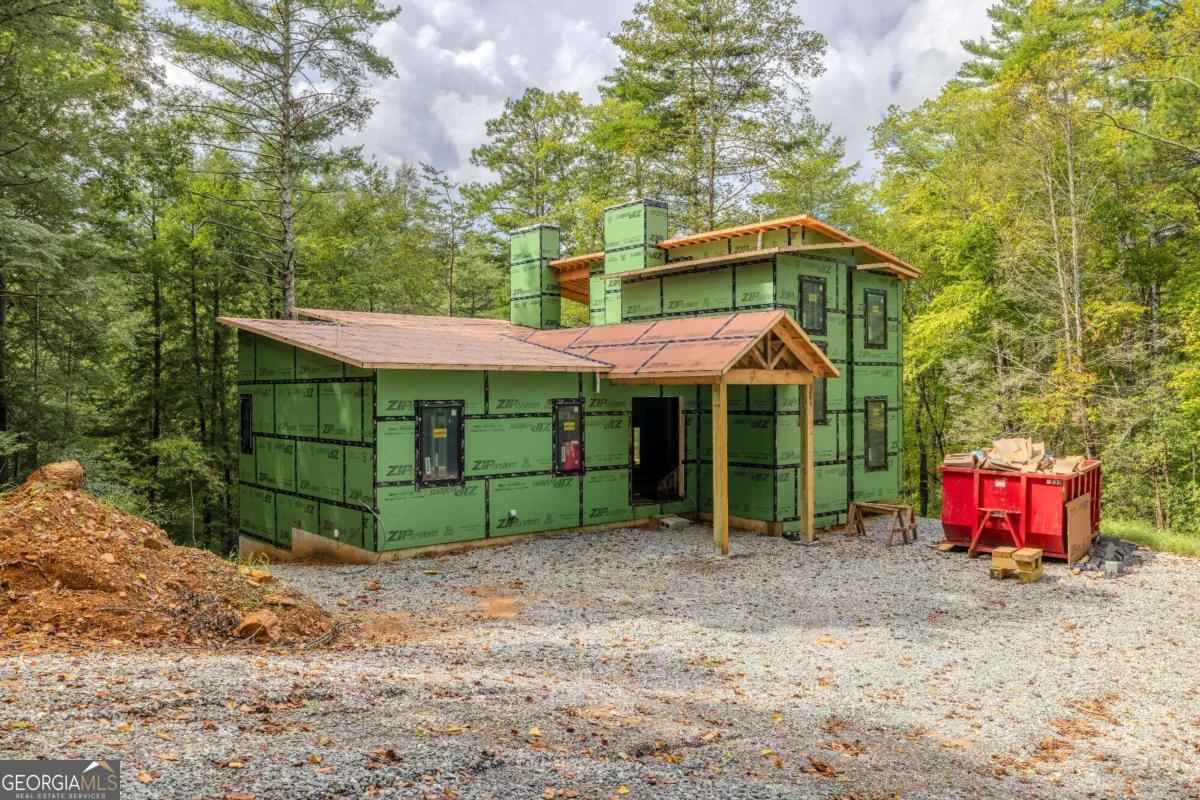 a view of a house with a yard and large trees