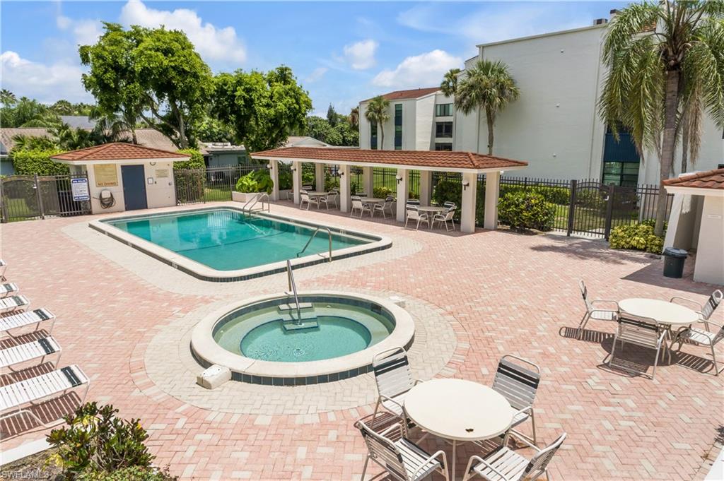 View of swimming pool featuring a hot tub and a patio area