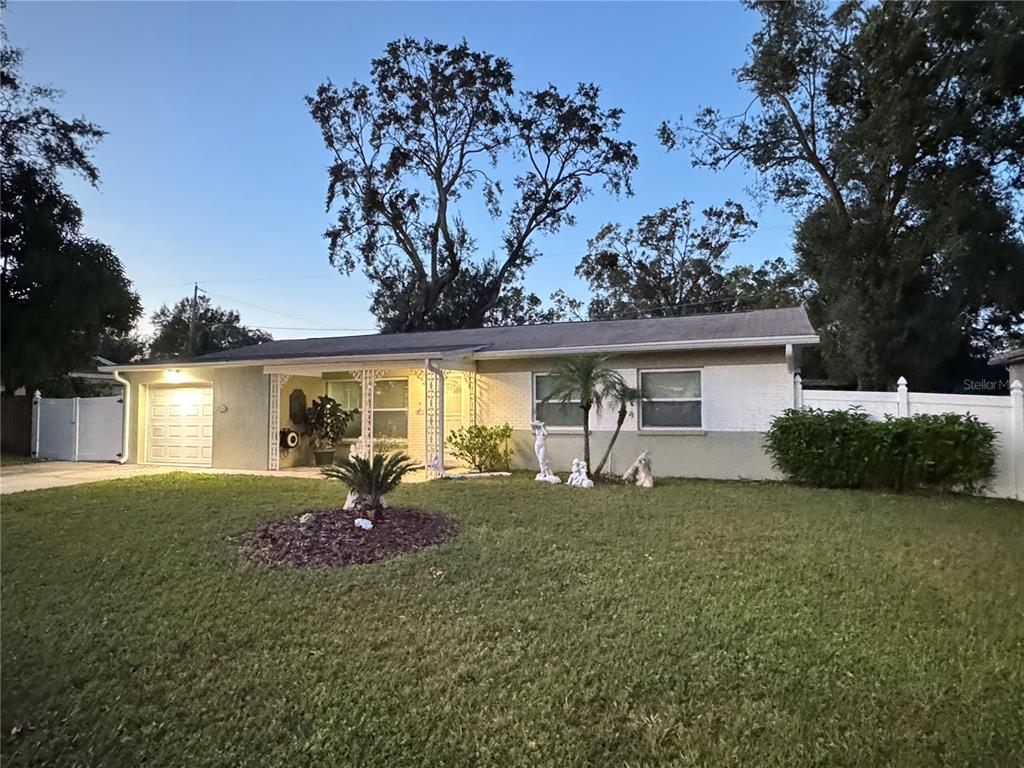 a view of a house with a big yard and large tree