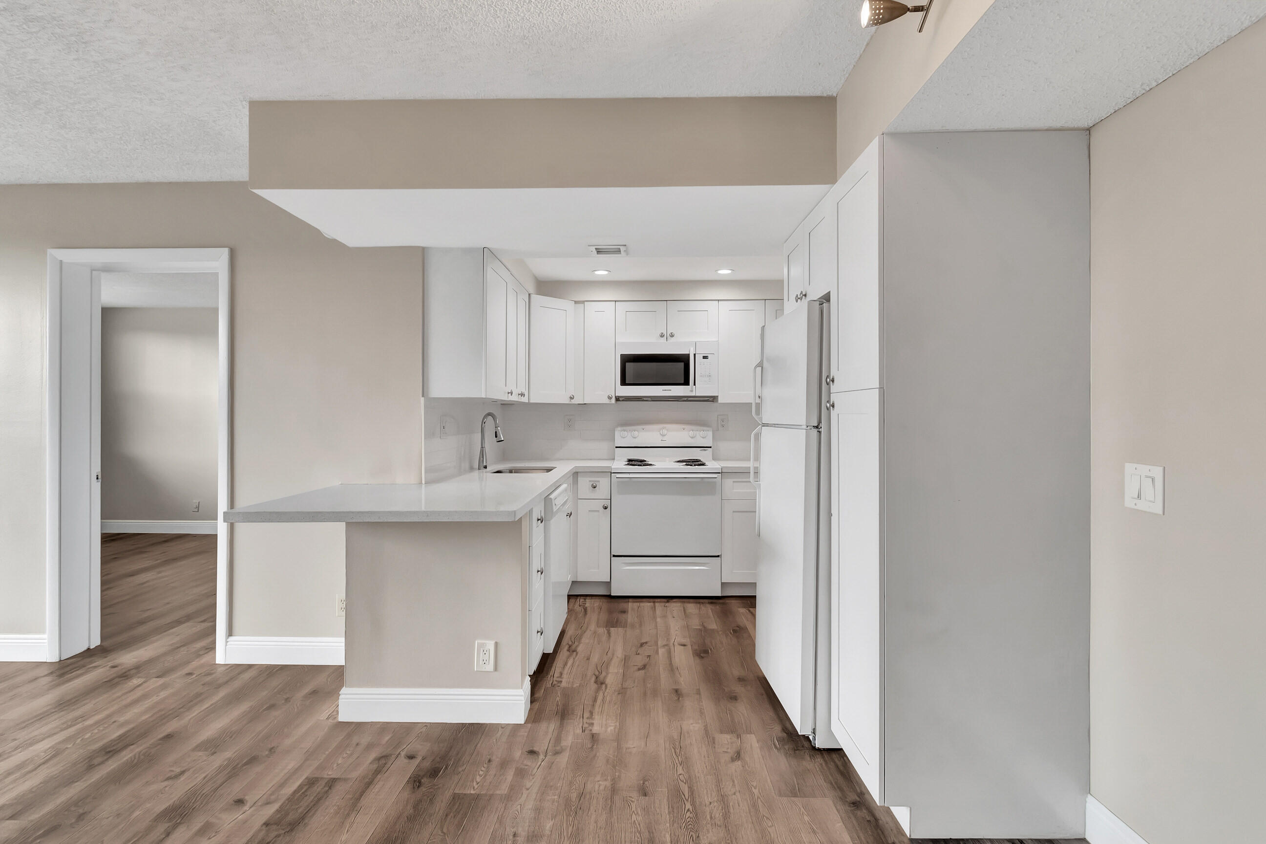 a kitchen with white cabinets stainless steel appliances and a sink