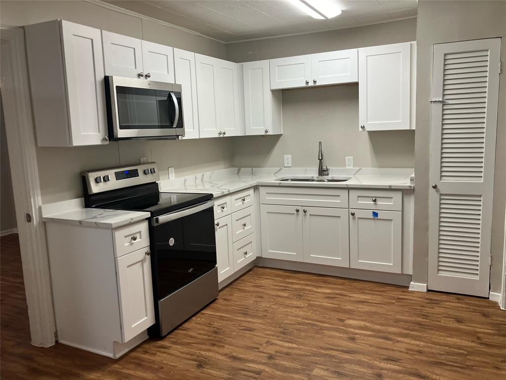 a kitchen with stainless steel appliances a sink stove and microwave