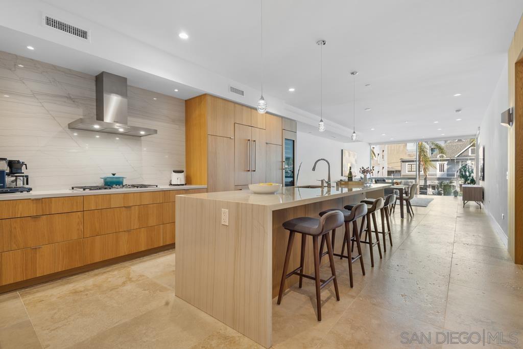 a kitchen with stainless steel appliances granite countertop a table chairs sink and cabinets