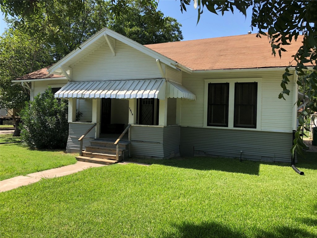 a view of a house with backyard and sitting area