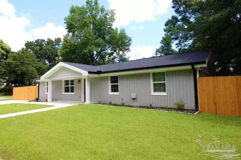 a front view of a house with yard and green space