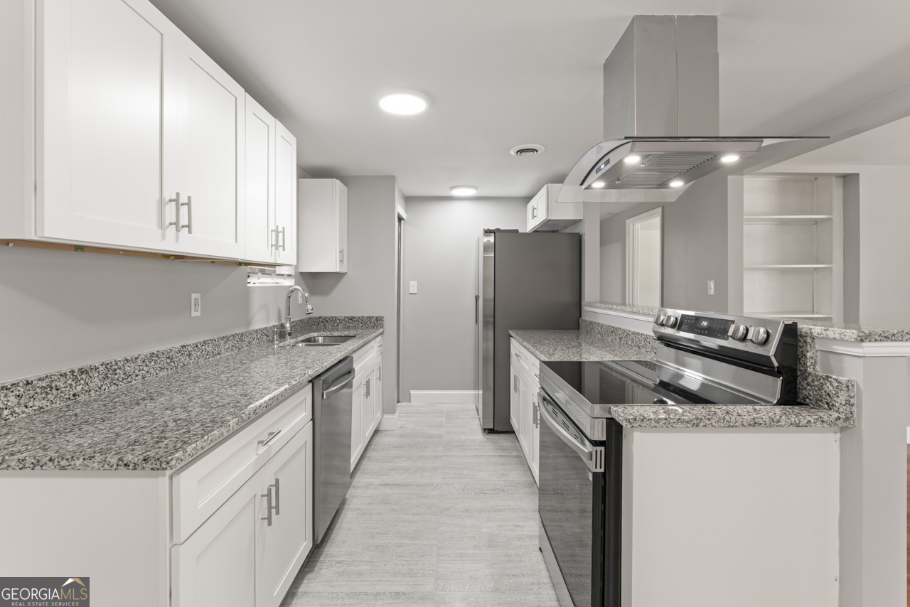 a kitchen with stainless steel appliances granite countertop a sink and a refrigerator