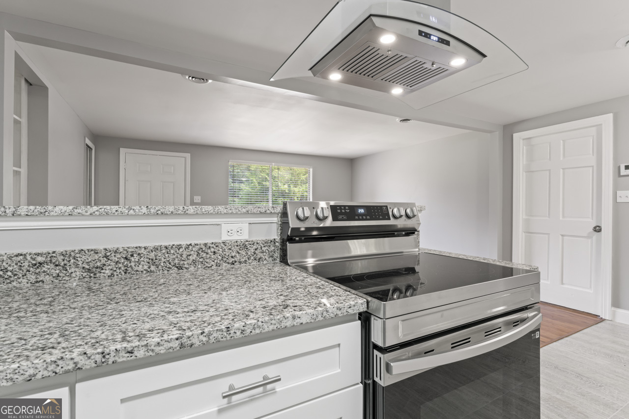 a kitchen with a stove and a white cabinets