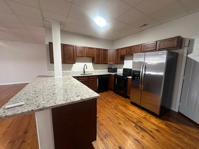 a kitchen with stainless steel appliances granite countertop a sink refrigerator and cabinets