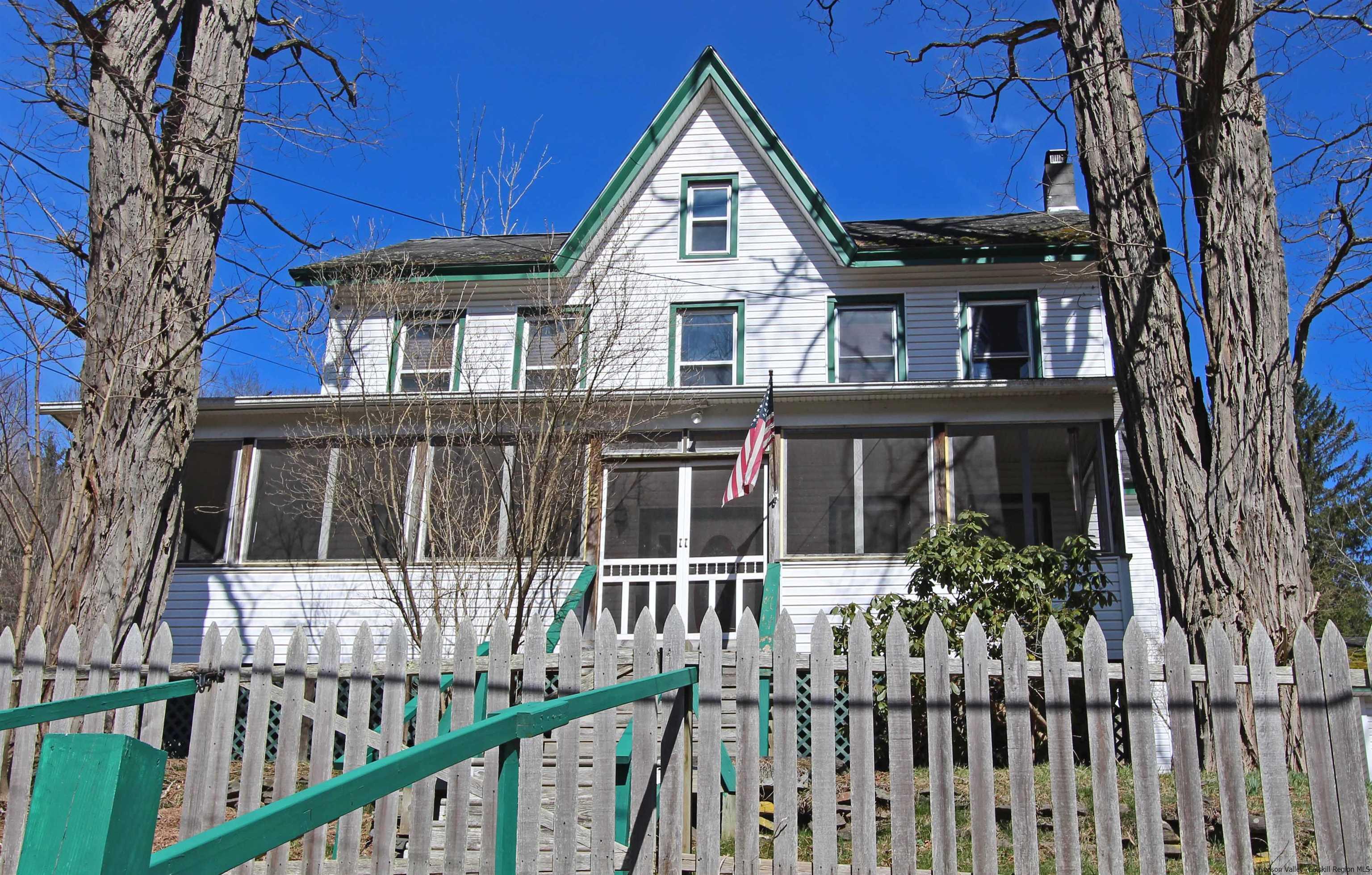 a view of a white house with large windows and a small yard