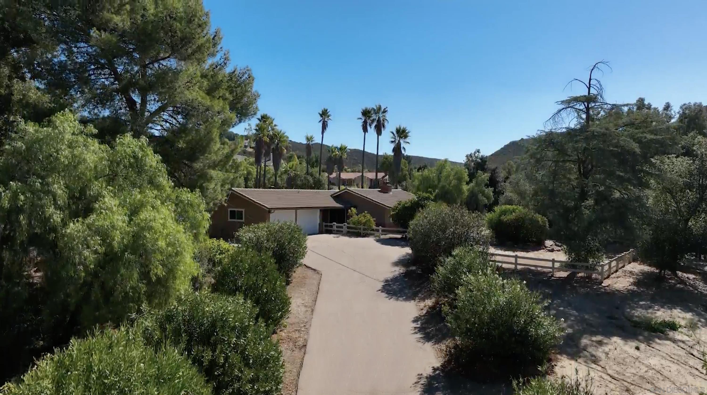 an aerial view of a house with a yard and outdoor seating