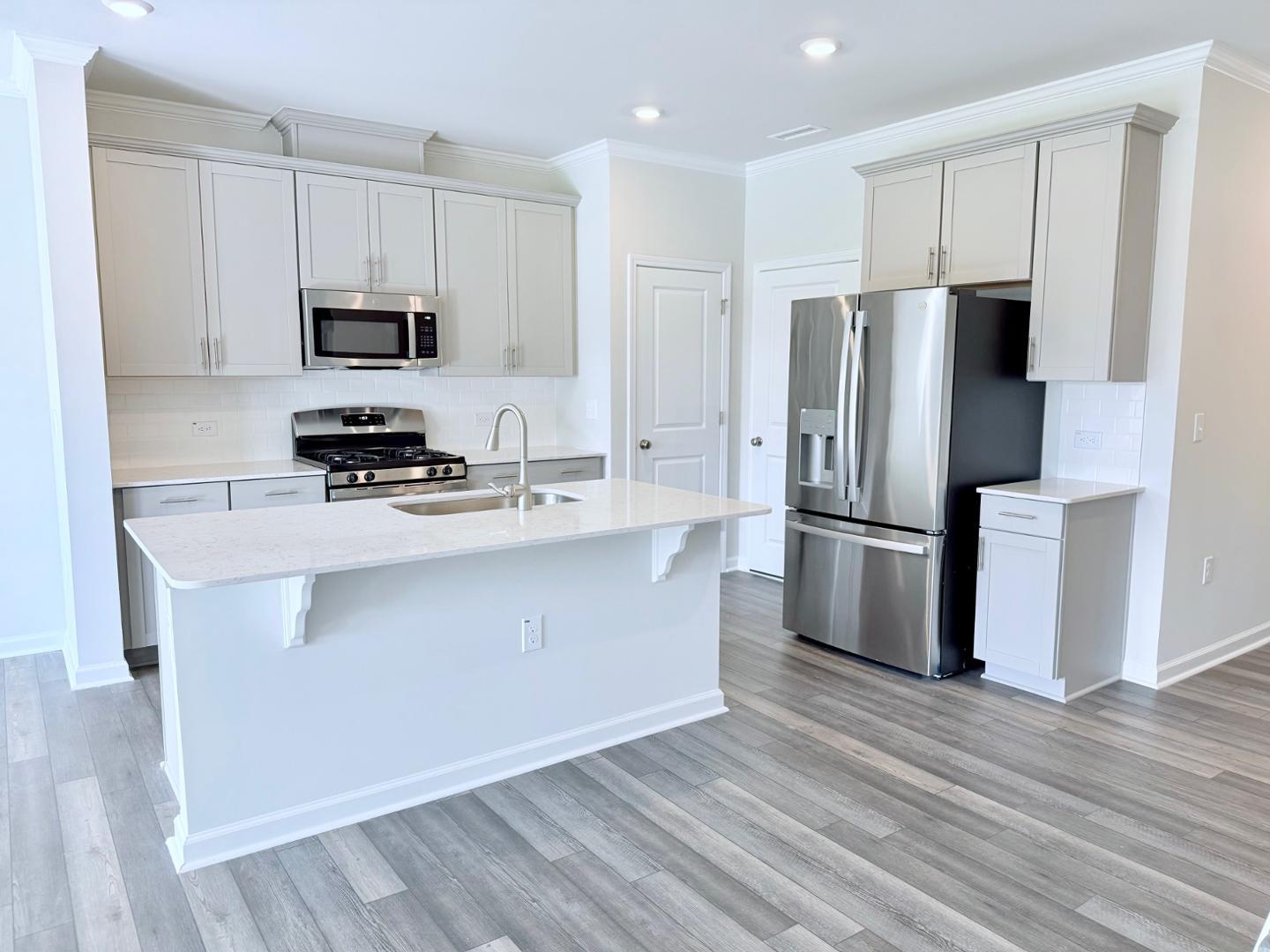 a kitchen with stainless steel appliances a refrigerator stove microwave and sink