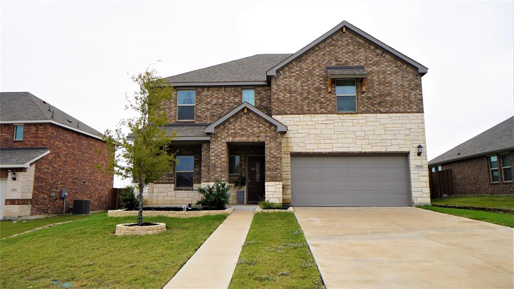 a front view of a house with a yard and garage