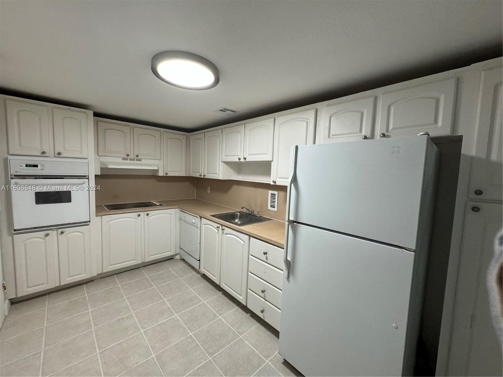 a kitchen with cabinets and white stainless steel appliances