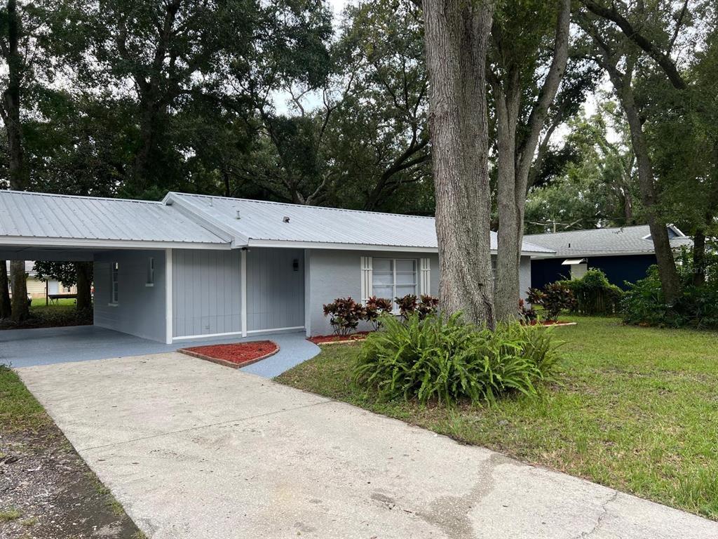 a view of a house with a patio and a yard