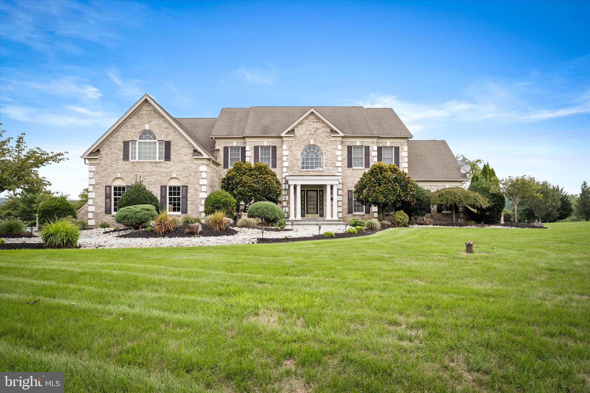 a front view of a house with a garden and yard