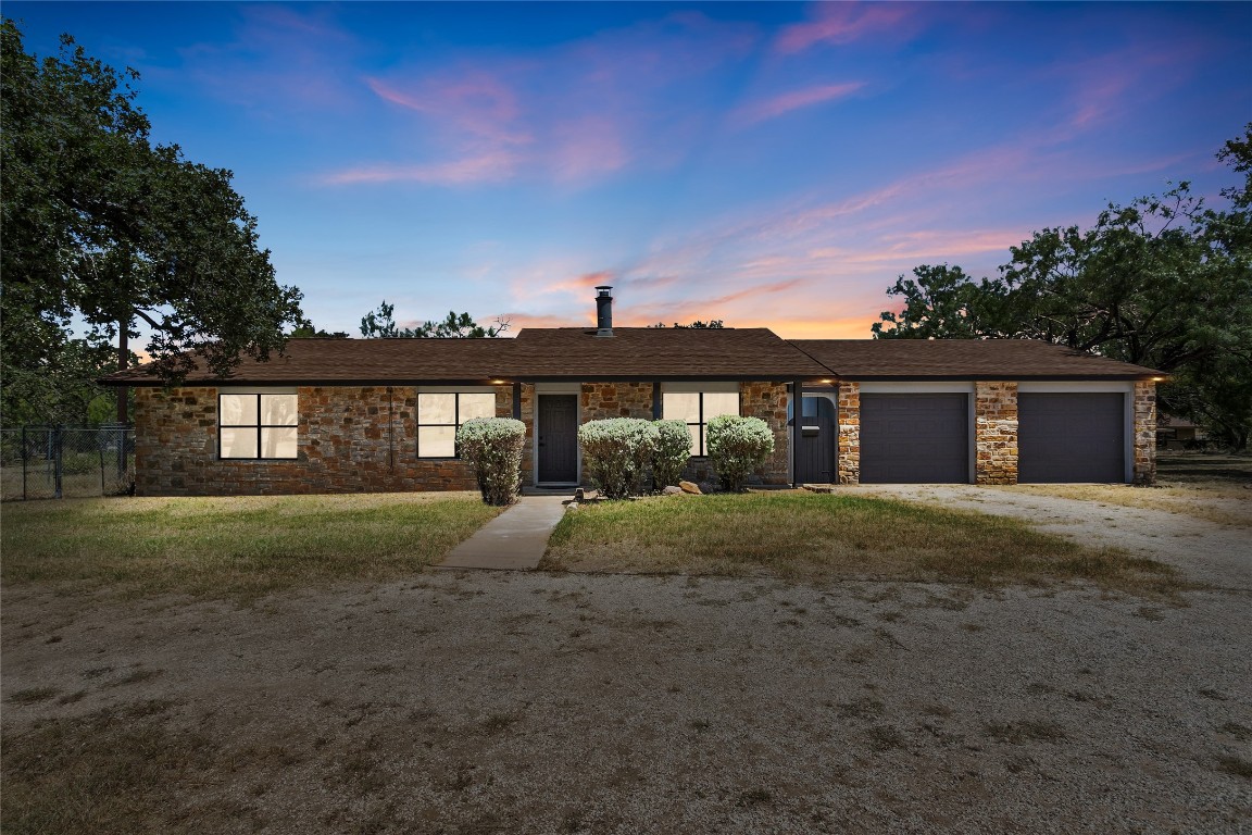 a view of a house with a yard and a tree