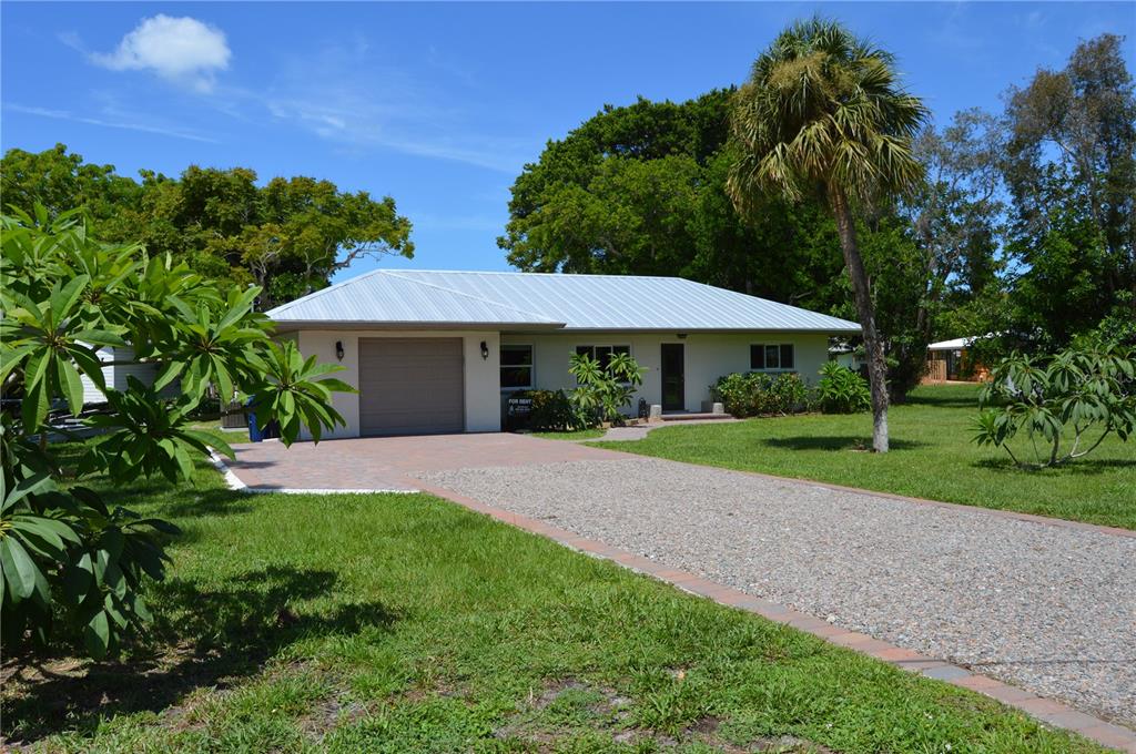 a front view of a house with yard and green space