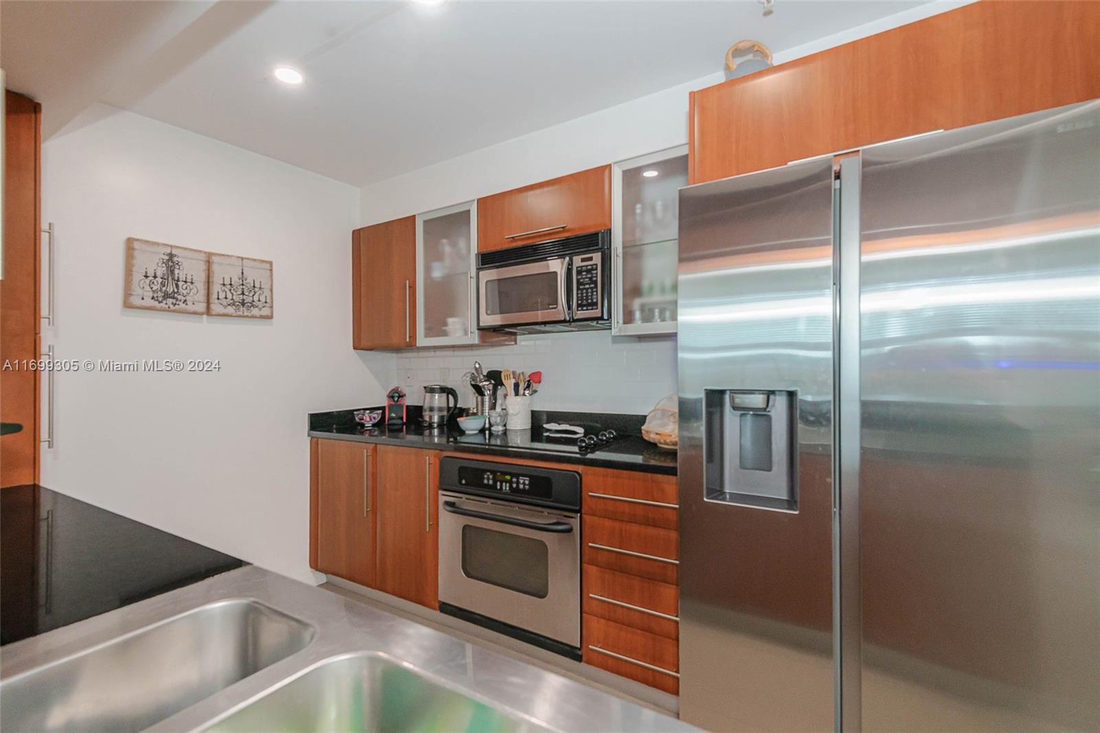 a kitchen with stainless steel appliances granite countertop a stove a sink and a refrigerator