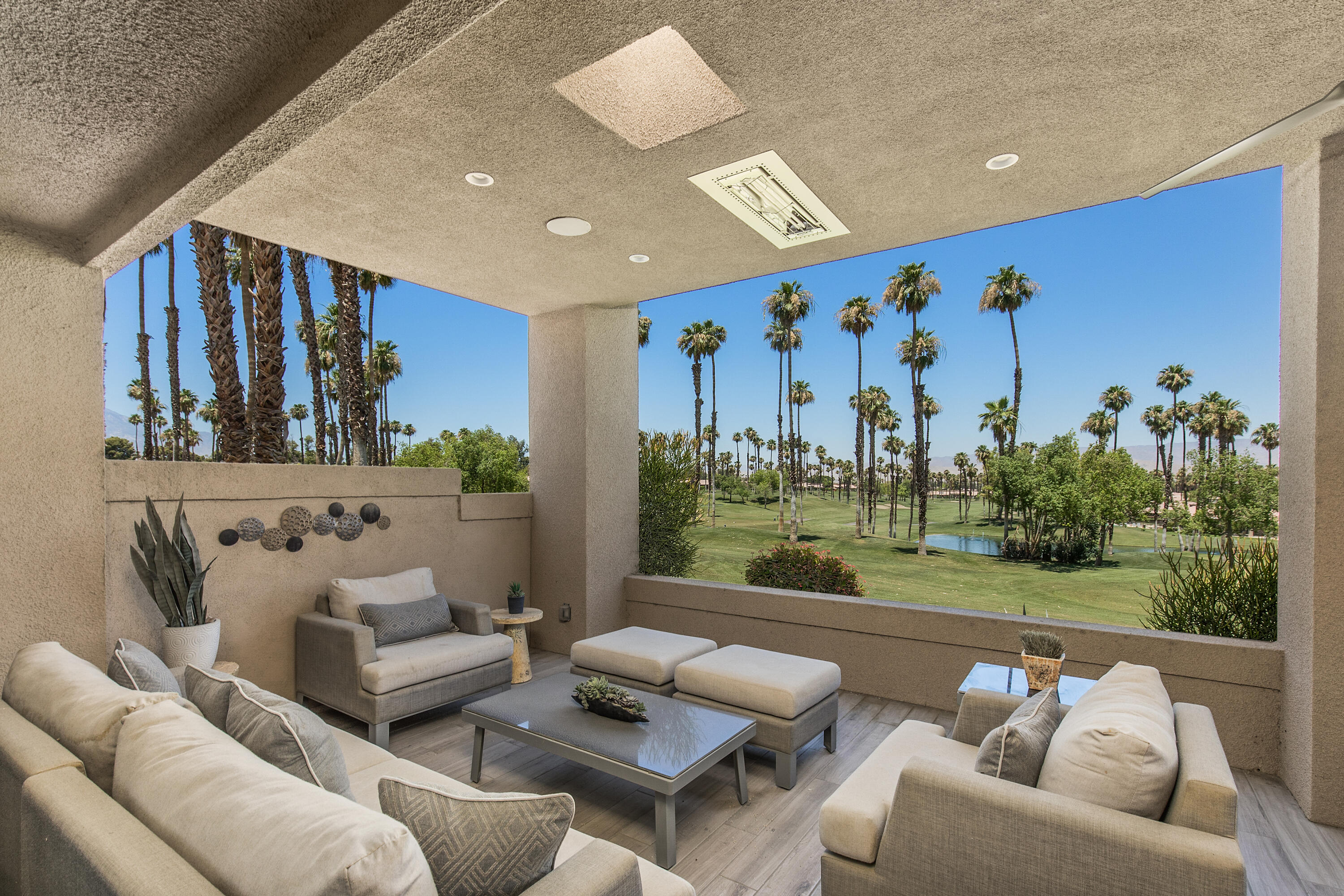 a outdoor living room with furniture and a large window