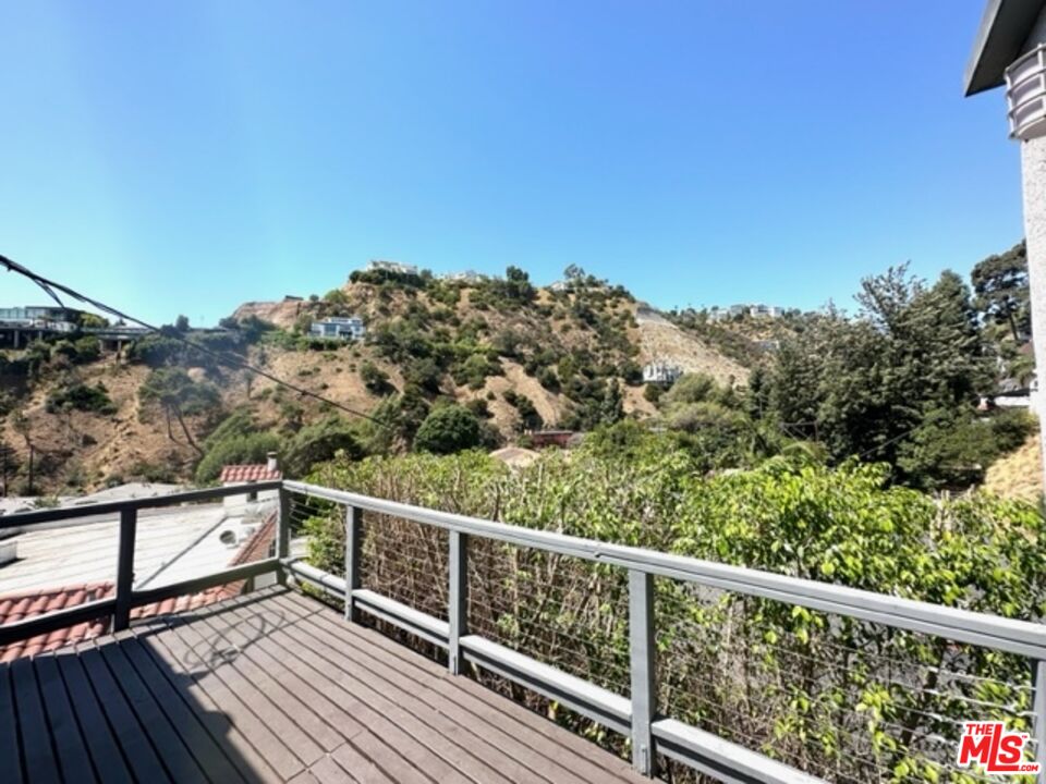 a view of balcony with wooden floor and fence