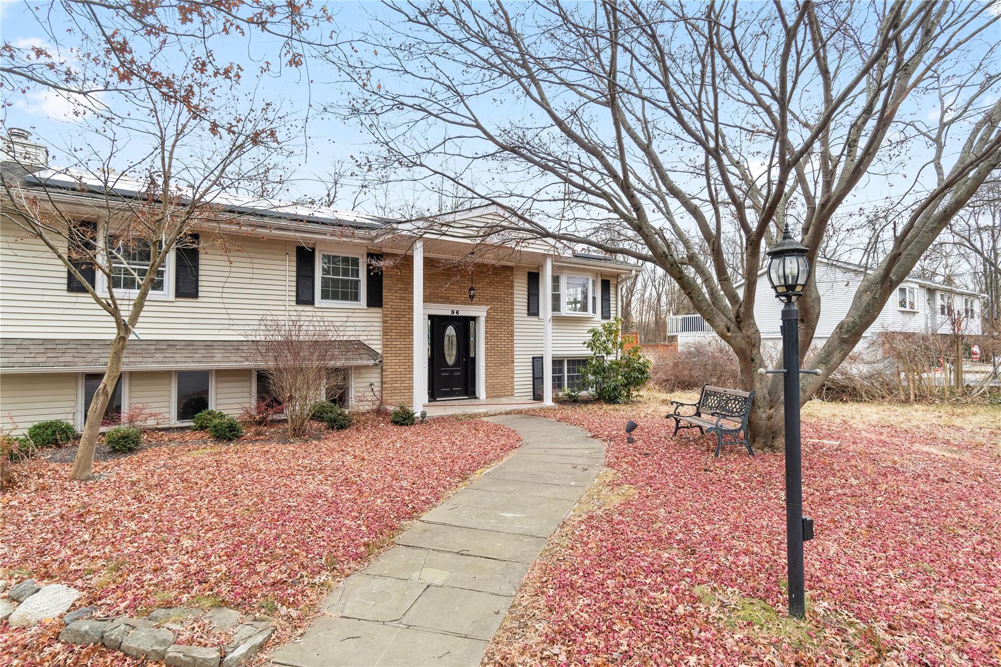 a front view of a house with a yard and trees