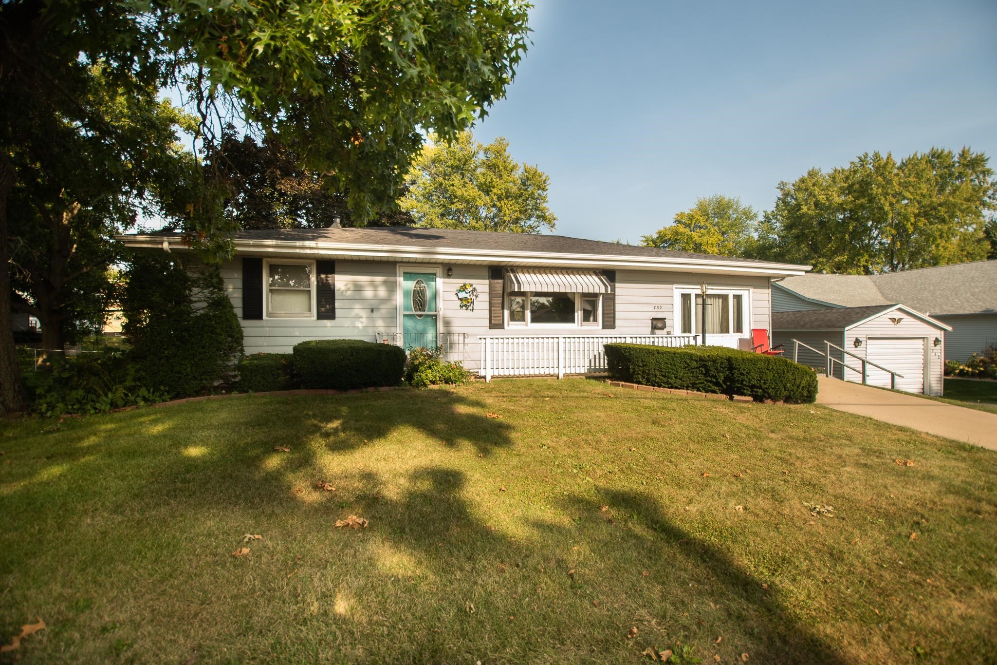 a front view of house with yard and trees around