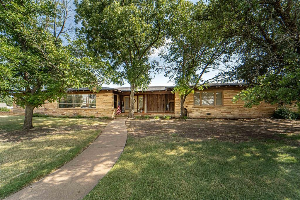 a front view of a house with a yard and trees