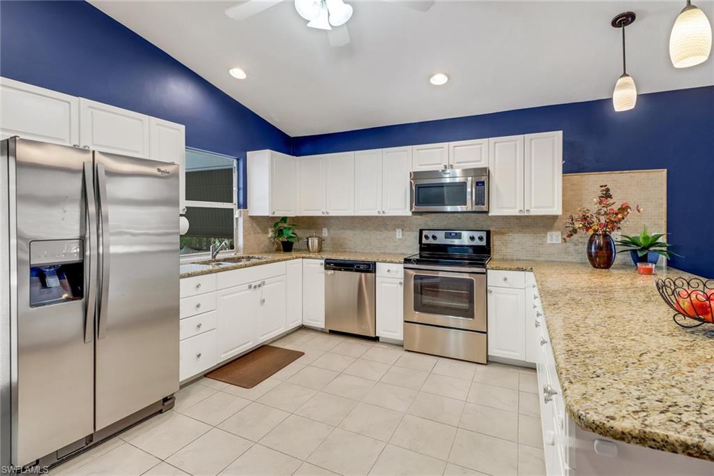 a kitchen with stainless steel appliances granite countertop a refrigerator and a stove top oven