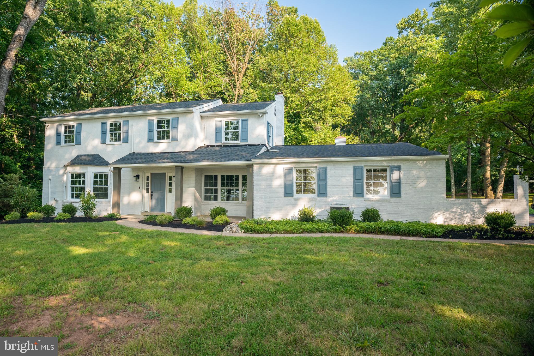 a front view of a house with a yard and trees