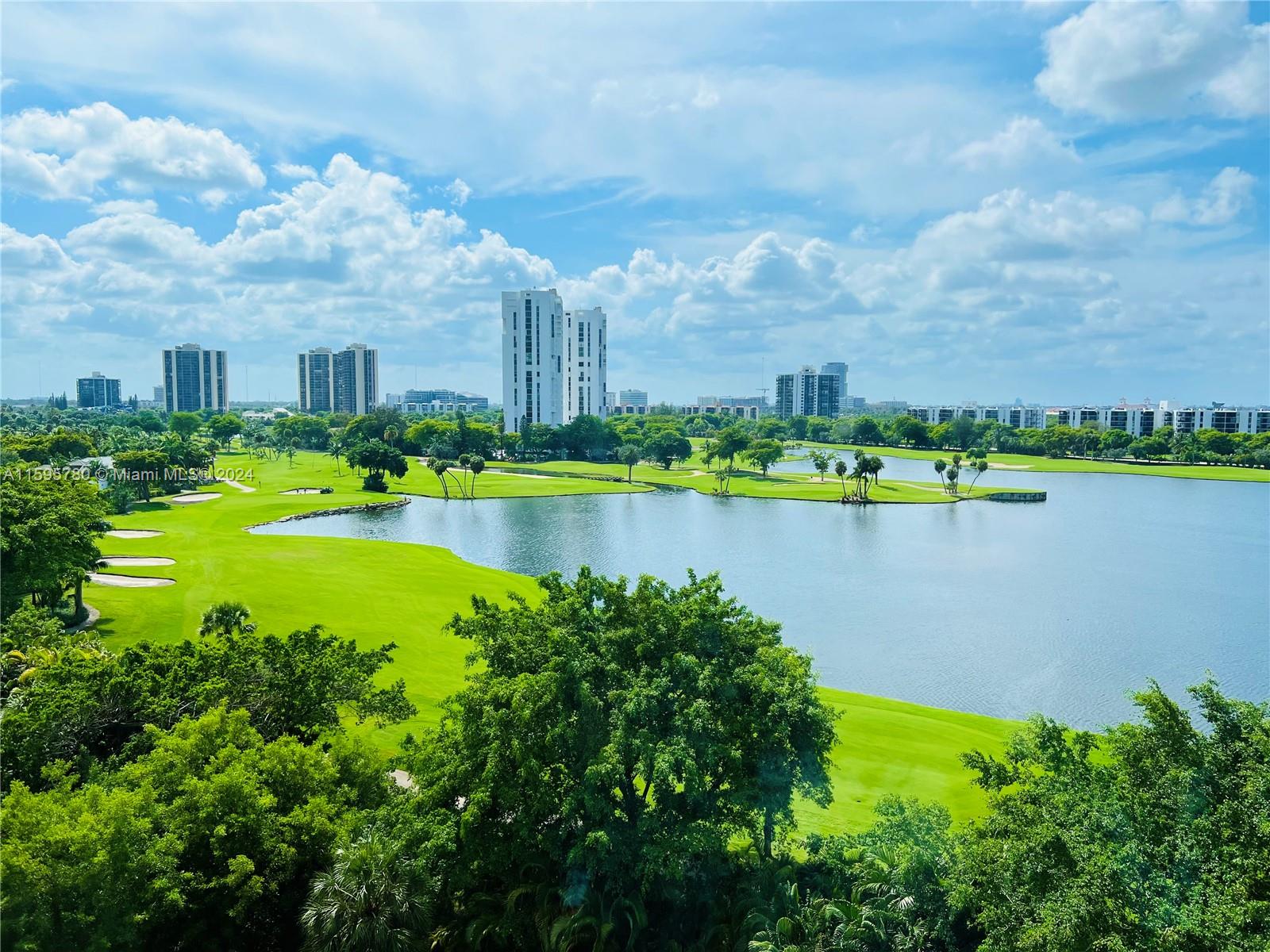 a view of a lake with a big yard and large trees