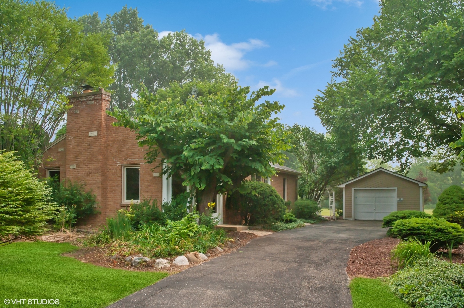 a front view of a house with a yard and trees