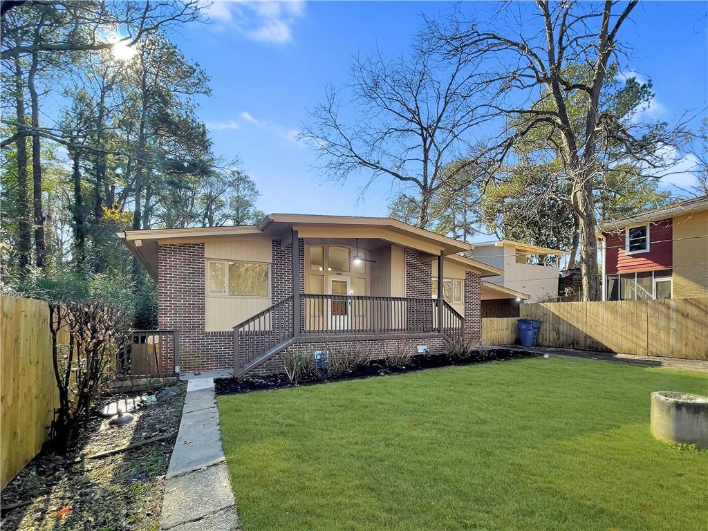 View of front of home with a front yard and a wooden deck