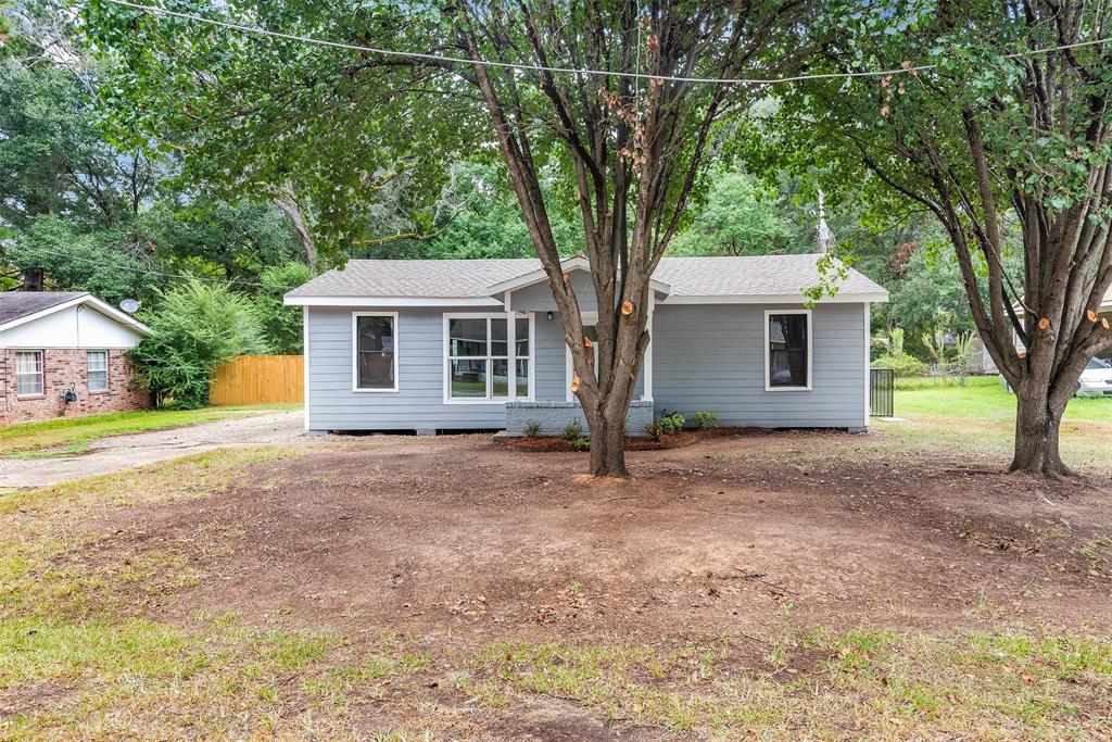 a front view of house with yard and trees