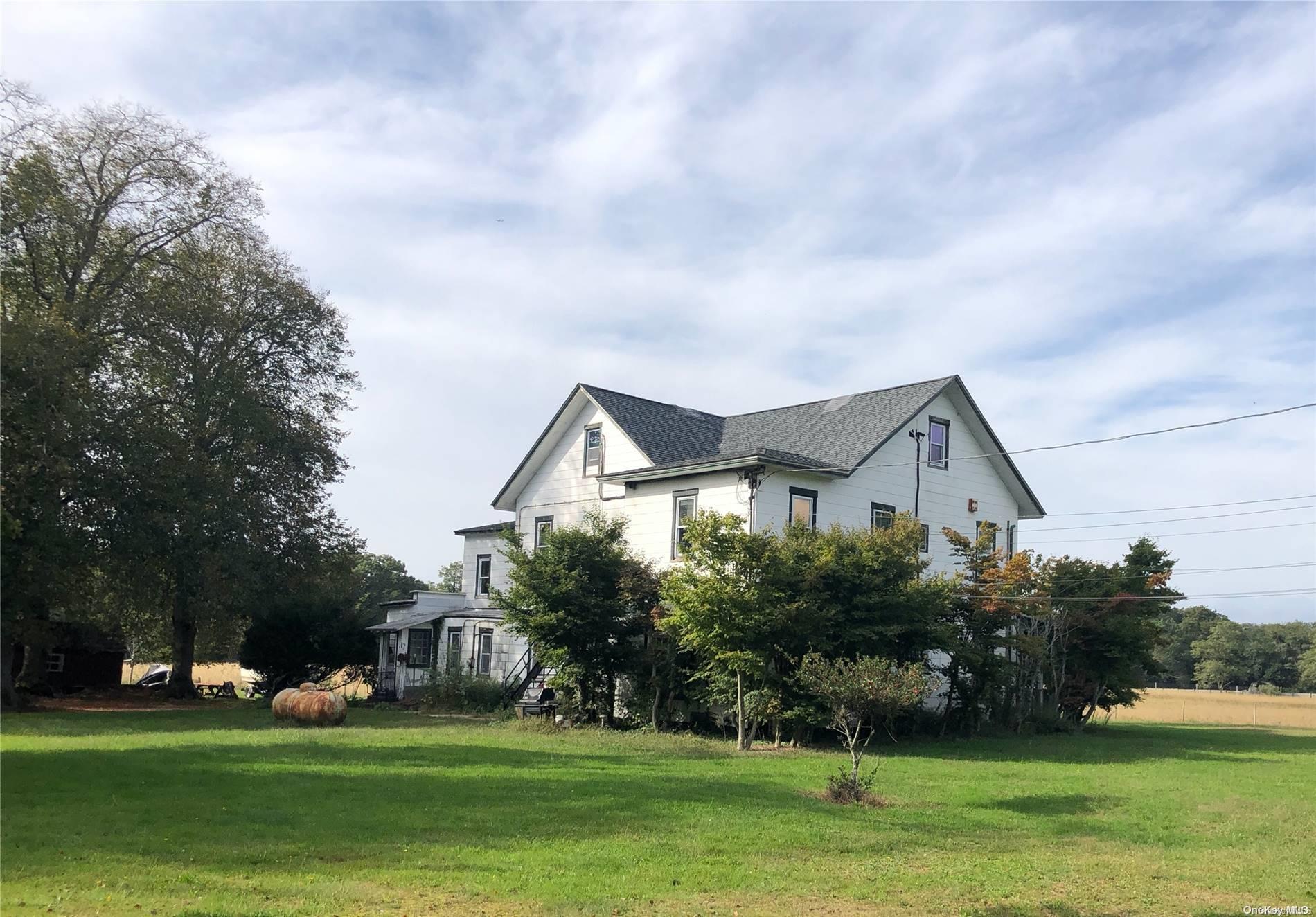 a front view of a house with a yard garden and trees