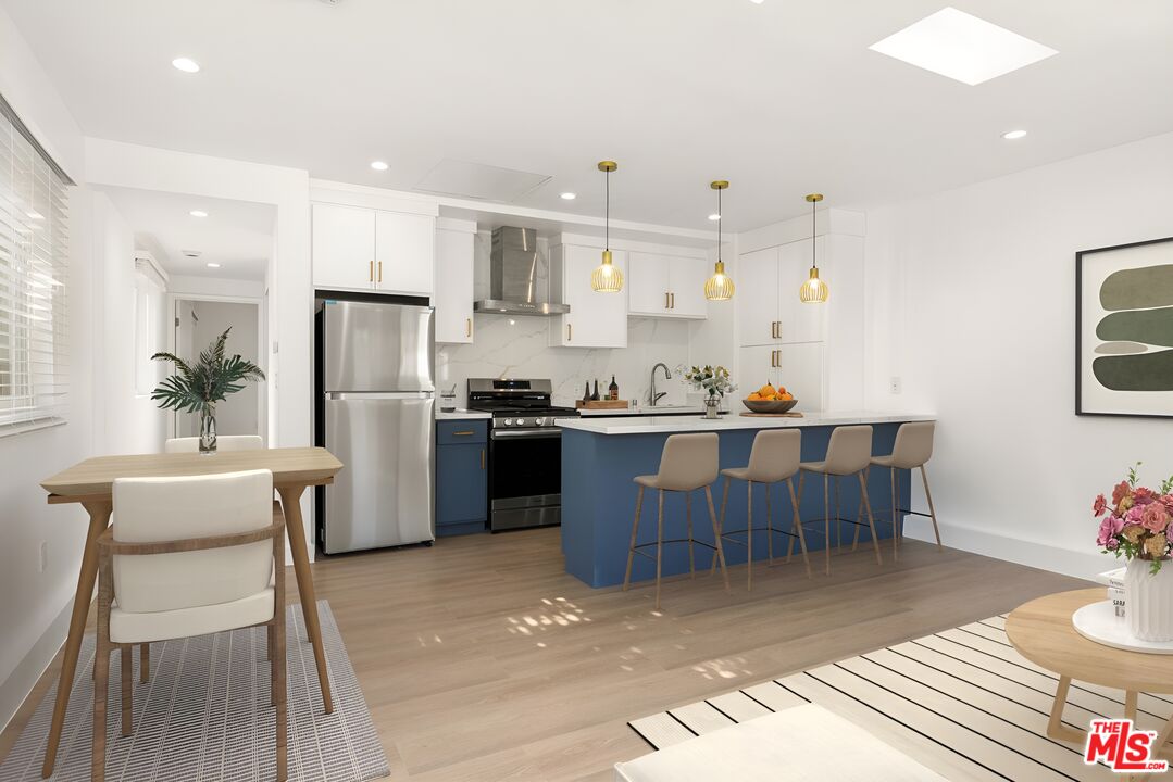 a kitchen with a dining table chairs refrigerator and cabinets