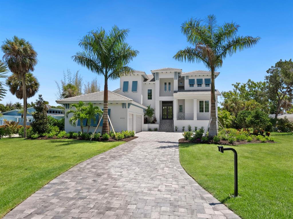 a front view of a house with a yard and palm trees