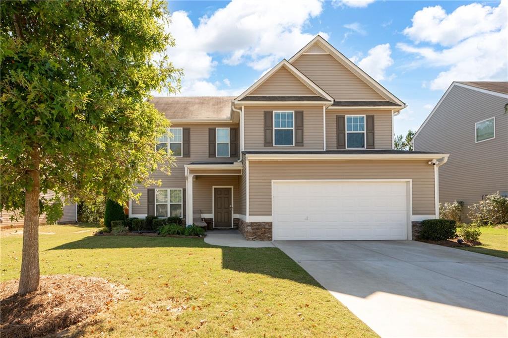 a front view of a house with a yard and garage