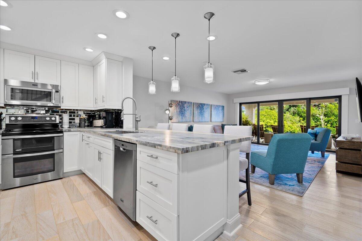 a kitchen with a sink window and stainless steel appliances