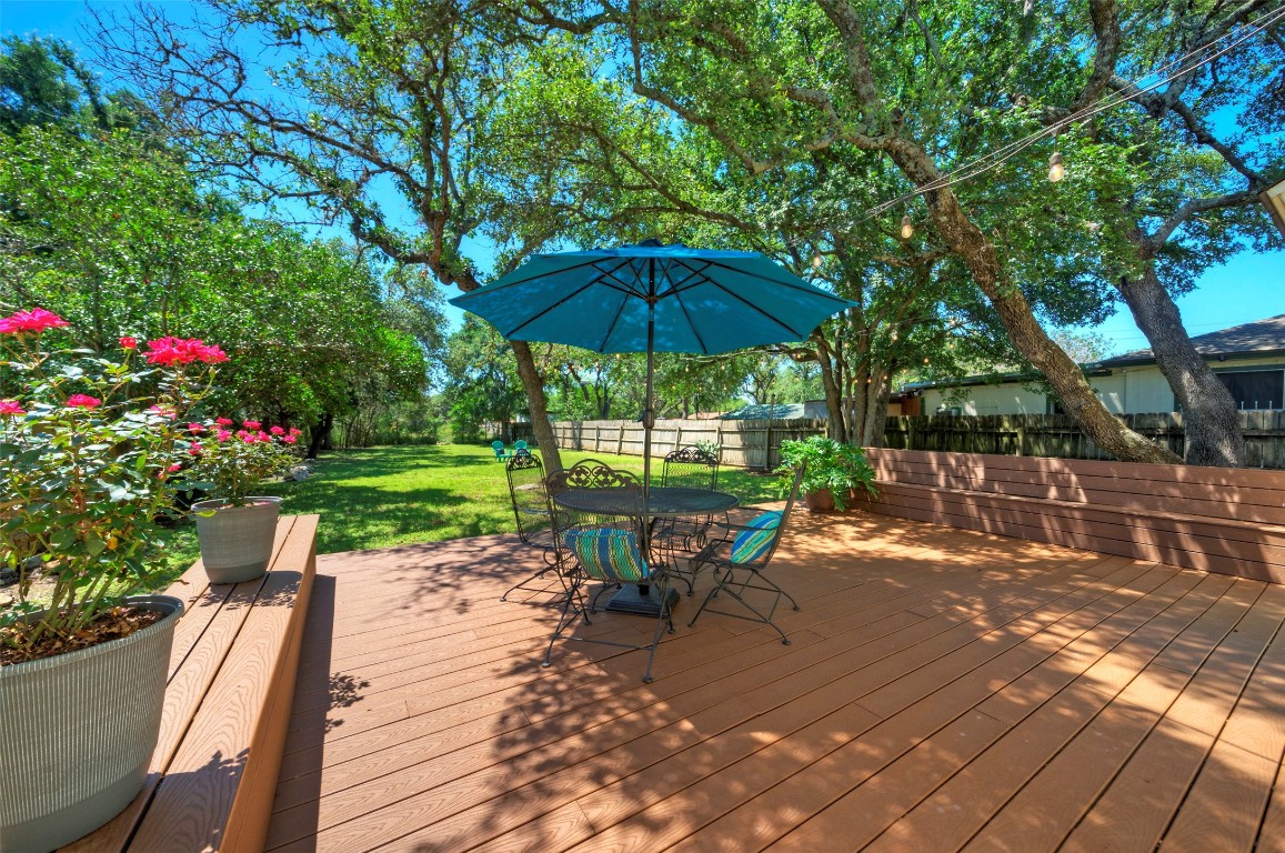 a view of a table and chairs under an umbrella in backyard