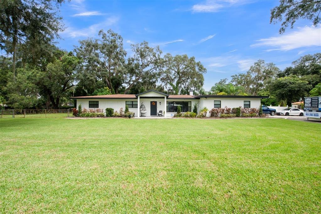 a front view of house with yard and trees in the background