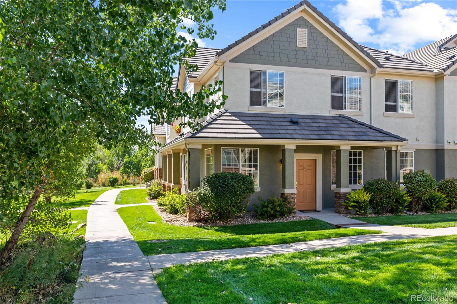 a front view of a house with a yard and potted plants