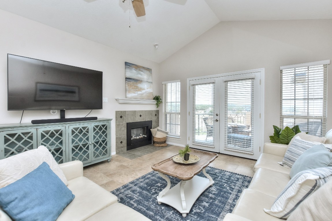 a living room with furniture a flat screen tv and a fireplace