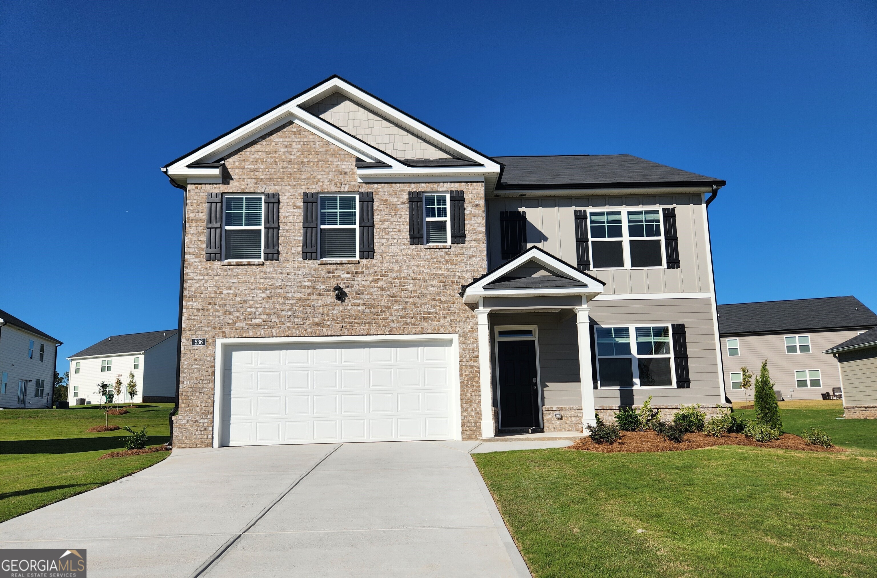 a front view of a house with a yard and garage