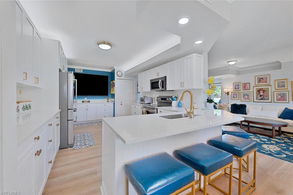 a large kitchen with cabinets table chairs and flat screen tv