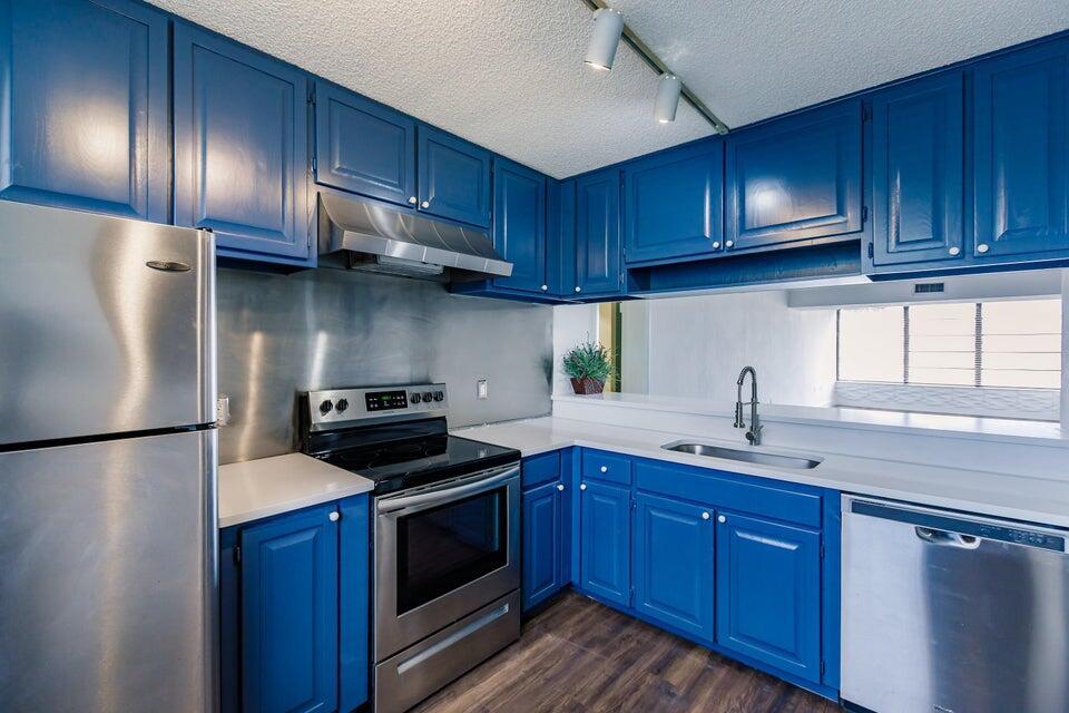 a kitchen with stainless steel appliances granite countertop wooden cabinets sink stove and refrigerator