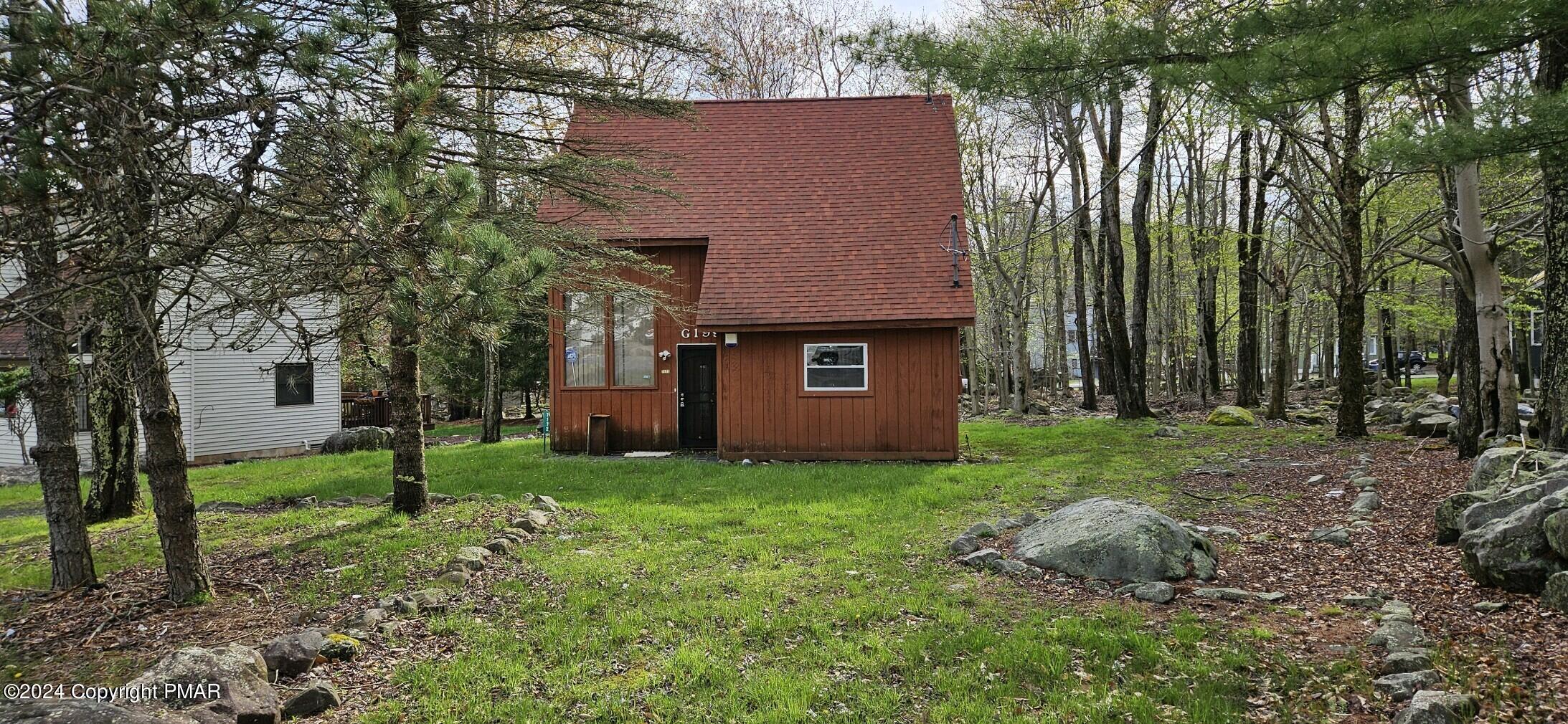 a view of a house with backyard and a tree