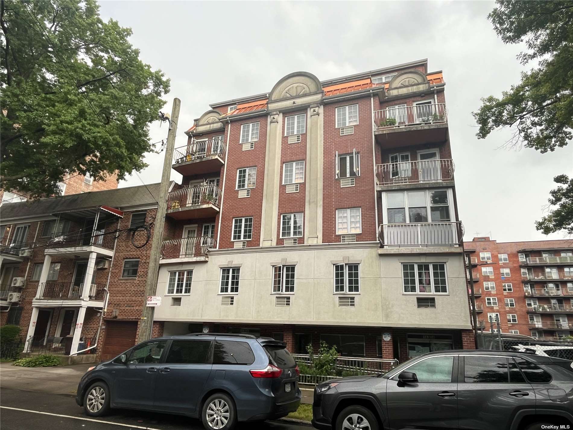 a front view of a residential apartment building with a parking space