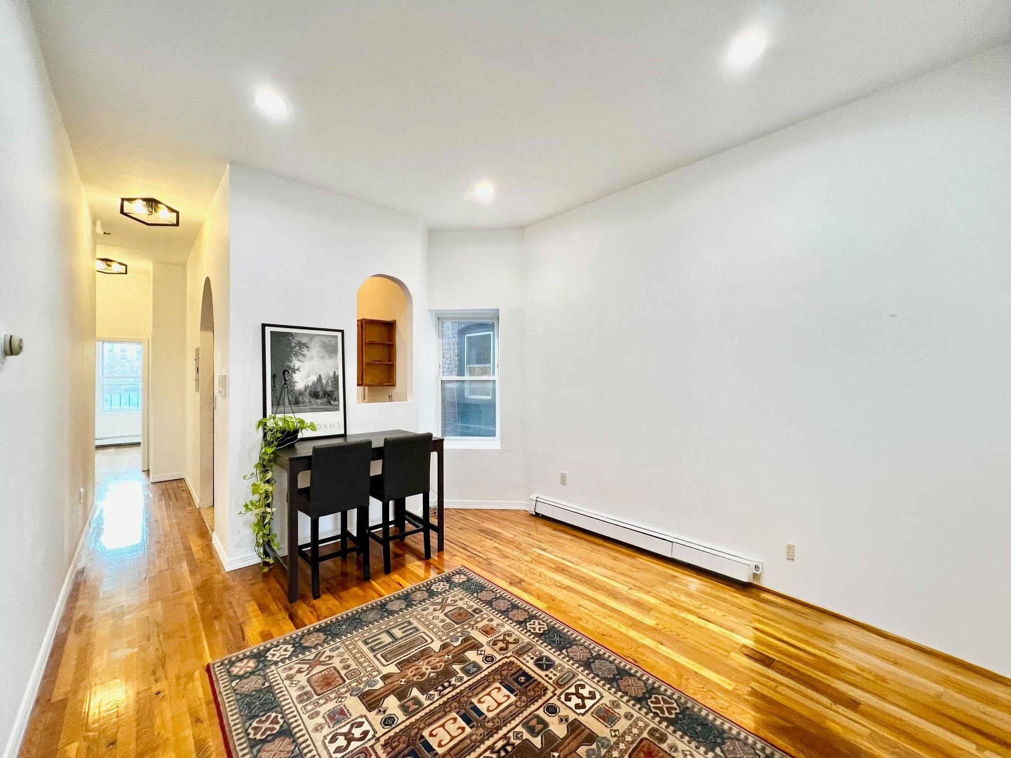 a view of a room with wooden floor table and chairs